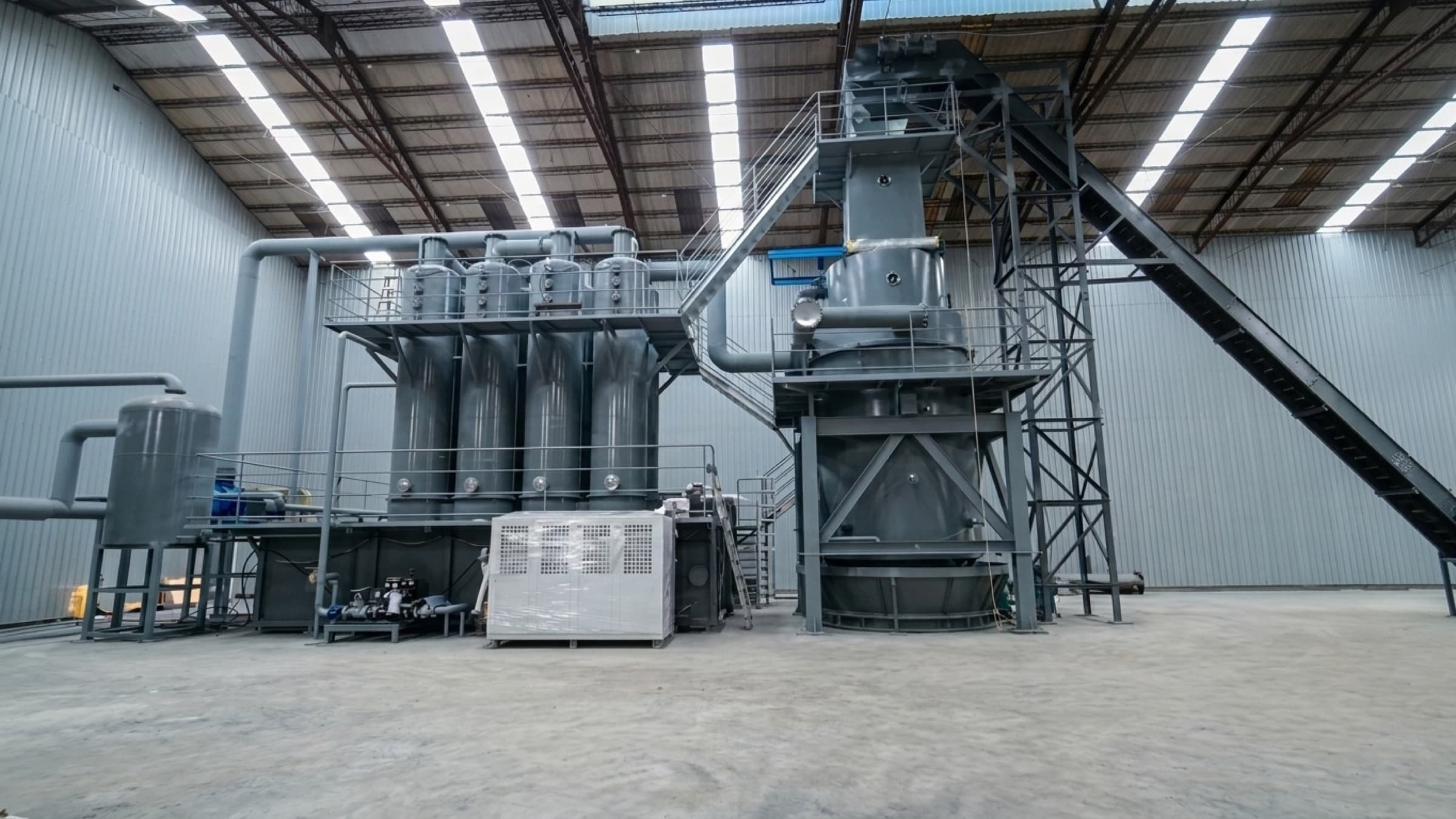 Biomass gasification plant inside an industrial building, with gasifier, gas cleaning columns and fuel conveyor, part of a CNP biomass power project in Taiwan